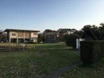 A building with a lawn and bushes

Description automatically generated