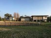 A grass field with houses in the background

Description automatically generated