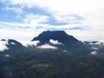 A mountain with clouds in the sky

Description automatically generated